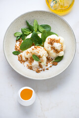 Plate with steamed cauliflower, ricotta cheese and fresh spinach leaves, vertical shot on a...