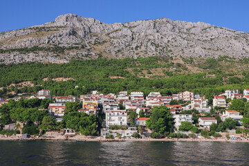 Fototapeta na wymiar Panoramic view to a village at Omis riviera from the sea, Omis, Omis riviera, Omis, Dalmatia, Croatia