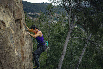 Nature's Challenge: Black-Haired Climber in Portrait amid the Woods and Subdued Sky