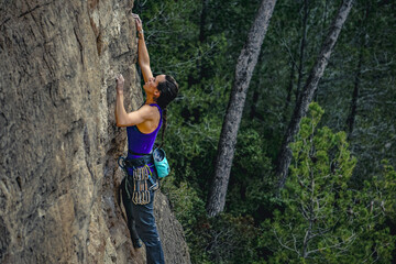 In the Wilderness: Determined Woman Climbing Amidst the Trees