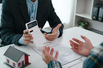 A real estate agent is talking with a client about buying a home or getting home insurance. Real estate agent buys, sells a house, agrees to buy a house.