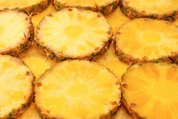 Pineapple juicy yellow slices as a background.