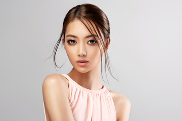 Tender Asian woman in a pink dress. Chinese refined and graceful girl. Cosmetology, clothes and...