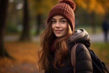 young caucasic woman with a whoolen hat girl walking in the park in autumn