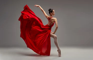 Abwaschbare Fototapete Tanzschule Ballerina. Young graceful woman ballet dancer, dressed in professional outfit, shoes and red weightless skirt is demonstrating dancing skill. Beauty of classic ballet.