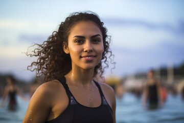 young latin woman in the beach looking to the camera with a smile