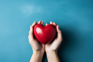 Woman's hand holding heart on blue background 
