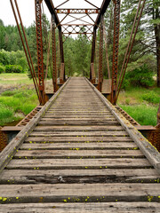 Obraz premium Rickety old bridge made of wood and rusted supports