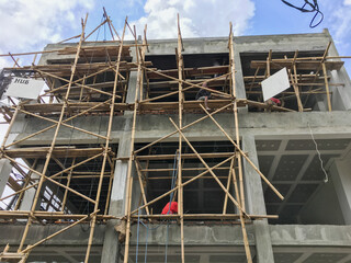 unsafe construction site of a building on the island of Bali, the scaffolding is made of bamboo and...