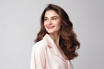 Obraz premium A beautiful, confident, and stylish young woman with long black hair smiles charmingly in a studio portrait.
