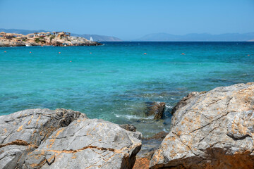 Fototapeta na wymiar Aponisos beach Greece Agistri island. Clear view of big rock at seaside, sea water blur rocky beach