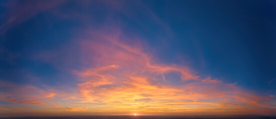 Fire on the sky: From high above, far sunset and orange and red colored streakes of cirrus clouds...