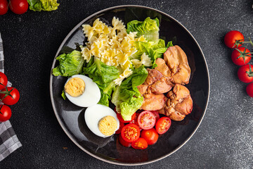 salad chicken liver, pasta salad , tomato, green leaf lettuce, boiled egg, farfalle snack meal food on the table copy space food background rustic top view