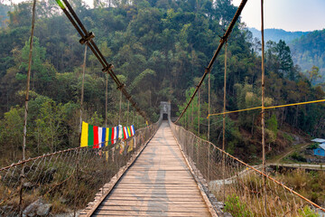 Hanging wooden bridge on Railey river surrounded by mountains at Bidyang Valley in Kalimpong district of India
 - obrazy, fototapety, plakaty