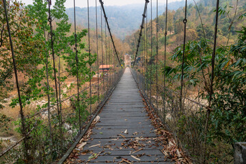 Hanging wooden bridge on Railey river surrounded by mountains at Bidyang Valley in Kalimpong district of India