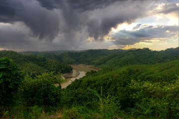 During the rainy season, the thick green hills blend into the thick black clouds in the sky. Sangu river flows below. Hilly region of Bandarban district of Bangladesh.