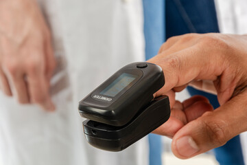 Man using a pulse oximeter in a finger