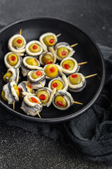 olive in anchovy fillet, anchovys roll stuffed olives apetizing seafood fish marinated appetizer meal food snack on the table copy space food background rustic top