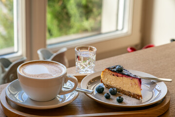 Blueberry cake with a cappuccino in a coffee shop for breakfast