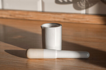 White porcelain mortar and pestle on the kitchen countertop on a sunny day