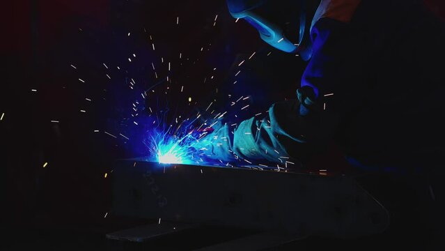 Workers wearing industrial uniforms and Welded Iron Mask at Steel welding plants, industrial safety first concept.