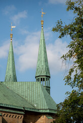 Church spires against clear blue sky with foreground trees