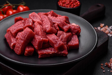 Raw organic meat beef or lamb cut into slices with salt, spices and herbs