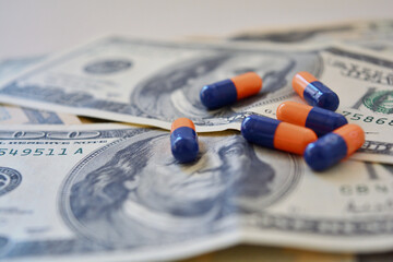 Opioids capsules over american bills, selective focus. Concept of big pharma profit.