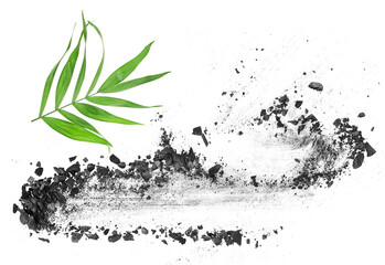 Broken activated charcoal with bamboo leaf isolated on a white background, top view.