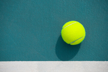 Tennis ball on the blue-coated court