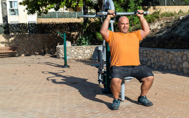 Adult man exercising on the bio healthy park machine.