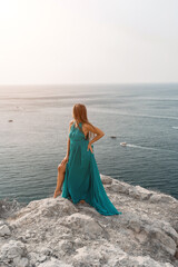 Woman sea trevel green dress. Side view a happy woman with long hair in a long mint dress posing on a beach with calm sea bokeh lights on sunny day. Girl on the nature on blue sky background.