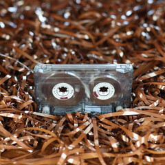 Audio cassette, on the background of the tape. Retro style, classic. Outdated equipment, a lot of film from cassettes. Cassette for radio, old music of 1970-1990 years. Vintage record, nostalgia