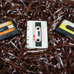 Audio cassette, on the background of the tape. Retro style, classic. Outdated equipment, a lot of film from cassettes. Cassette for radio, old music of 1970-1990 years. Vintage record, nostalgia