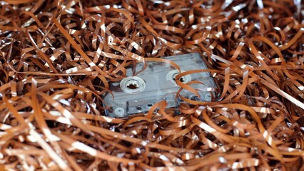 Audio cassette, on the background of the tape. Retro style, classic. Outdated equipment, a lot of film from cassettes. Cassette for radio, old music of 1970-1990 years. Vintage record, nostalgia
