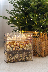 Decorate the Christmas tree. Christmas decorations in storage box. Transparent plastic containers with shiny and gold bows, balls, toys and with garland. Storage decorations after the holidays.