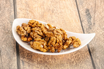 Cracked unshelled walnut in the bowl