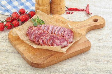 Sliced salami sausages over board