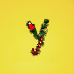 Christmas alphabet. Letter Y made of pine tree branches, Christmas lollypop, ornament and red...