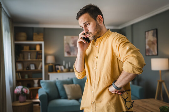 One adult man with eyeglasses at home use mobile phone have problem