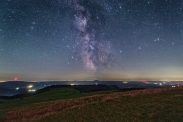 The Milky Way over the summit of the mountain Wasserkuppe in the Rhoen in Germany. - obrazy, fototapety, plakaty