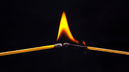 Burning match on a black background. Heat and light from fire flame