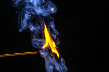 Fire and smoke. Burning and smoking match on a black background. Heat and light from fire flame