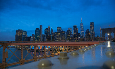 Naklejka premium Midtown Manhattan at sunset, New York City. Panoramic aerial view of city skyscrapers at dusk through Brooklyn bridge