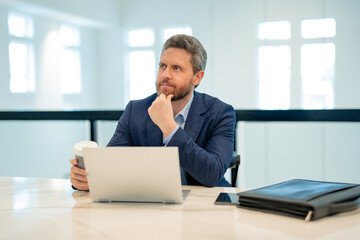 Serious business man working in office. Handsome business man in casual suit using laptop in office. Business man office worker in formal suit. Office manager ceo business man using laptop.