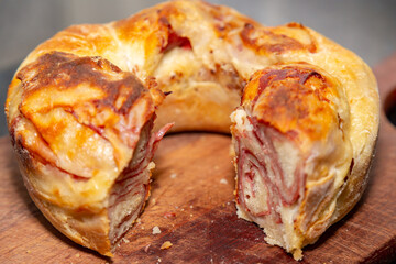 Traditional rustic mortadella bread on wooden board in selective focus