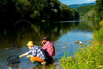 Mature senior man with friend fishing. Summer vacation. Happy cheerful people. Bearded men catching fish. Fisherman with fishing rod. Activity and hobby.