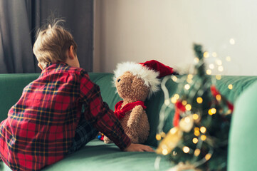 cute little boy dressing up teddy bear