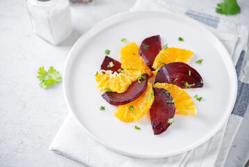 Beet orange cilantro salad with spicy olive oil vinegar sauce in a plate
