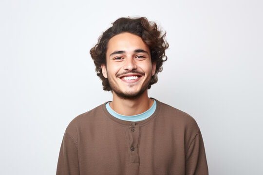 Picture of man with curly hair, wearing brown shirt and smiling. This image can be used to portray happiness, positivity, or friendly and approachable person.